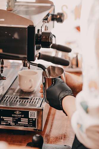 coffee cup person holding stainless steel pitcher cup